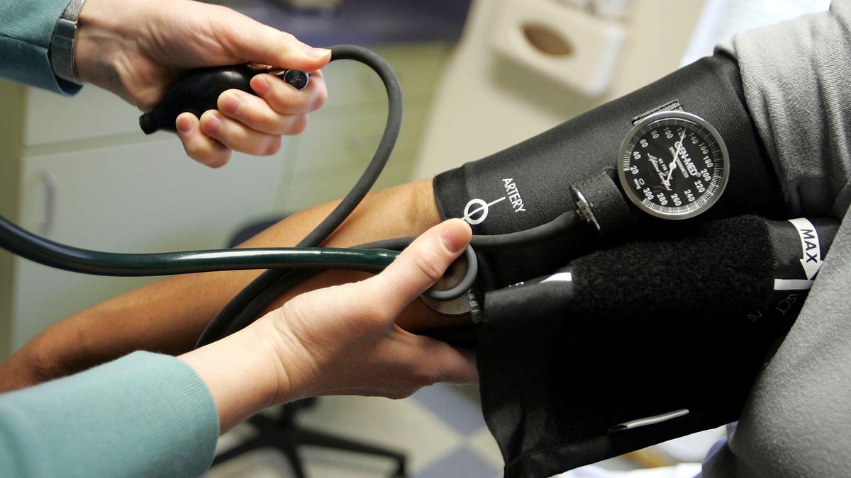 A doctor takes a patient's blood pressure