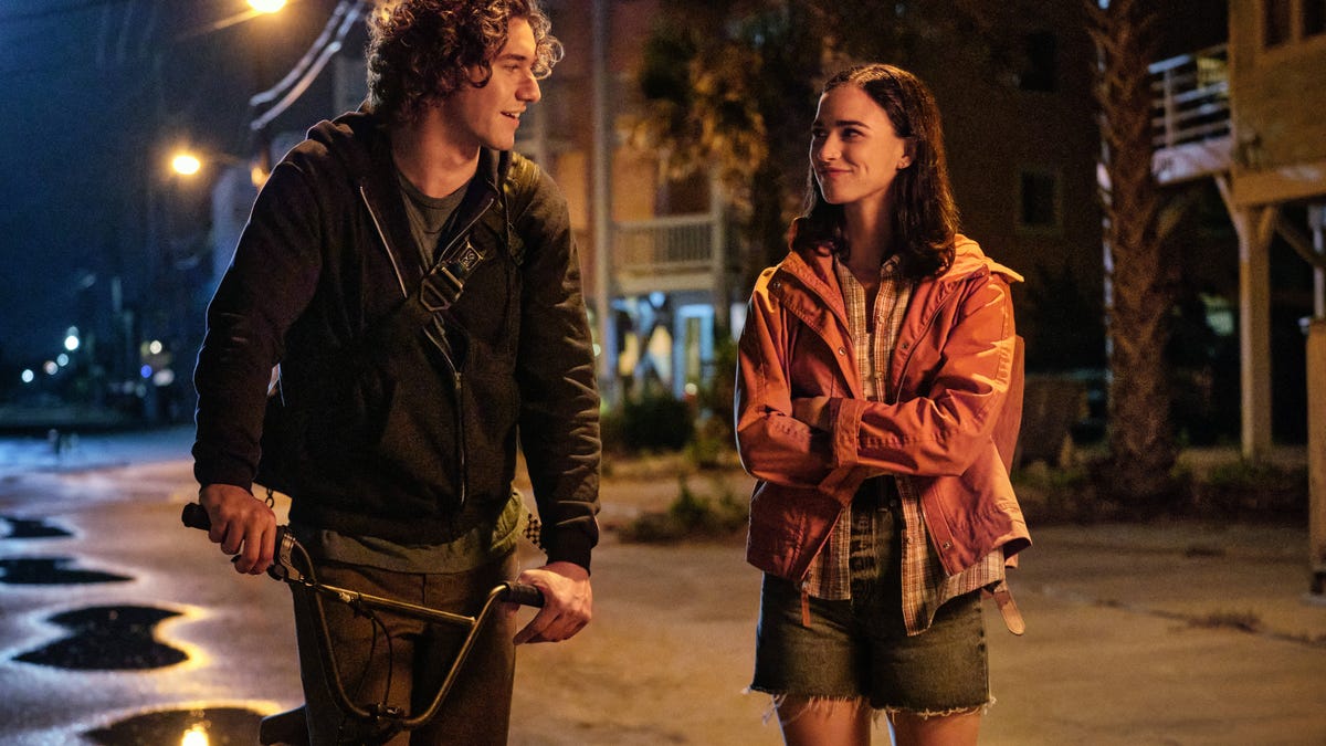 A young man and woman smile flirtatiously at each other