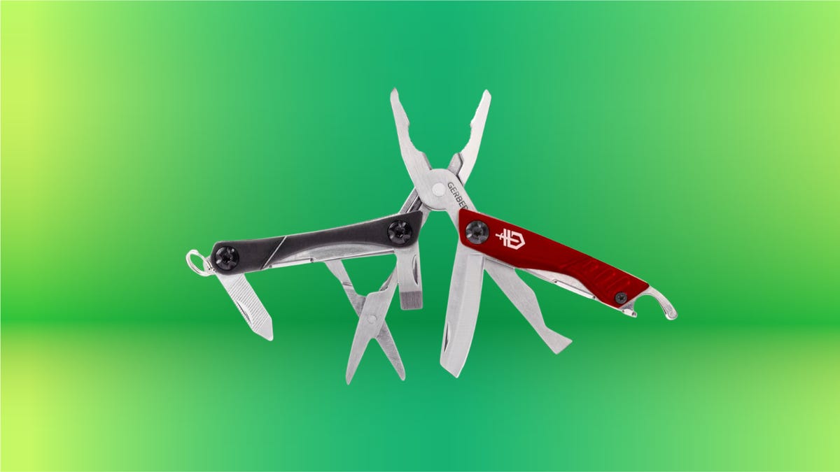 A red and black multitool with pliers, scissors and other tools extended for display, set against a green background.
