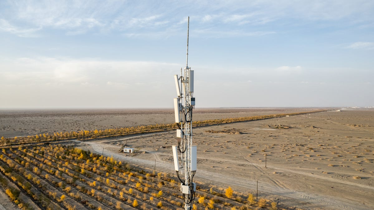 A cell tower in a rural, sparsely populated field.