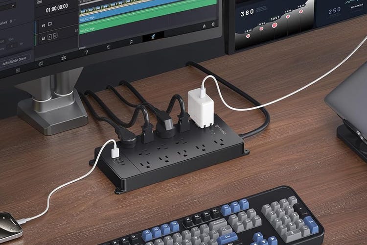 An illustration of a Trond surge protector at a computer desk with many devices plugged in.