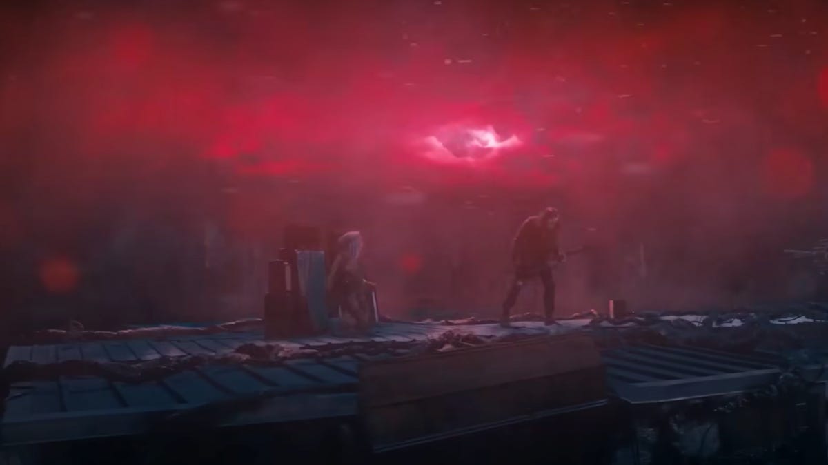 Eddie Munson playing guitar under an eerie sky in Stranger Things