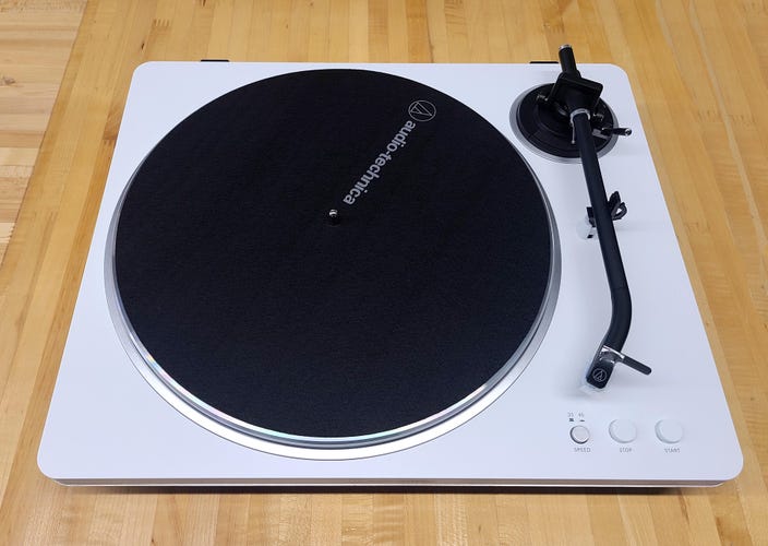 The white Audio-Technica LP70x on a wooden background. 