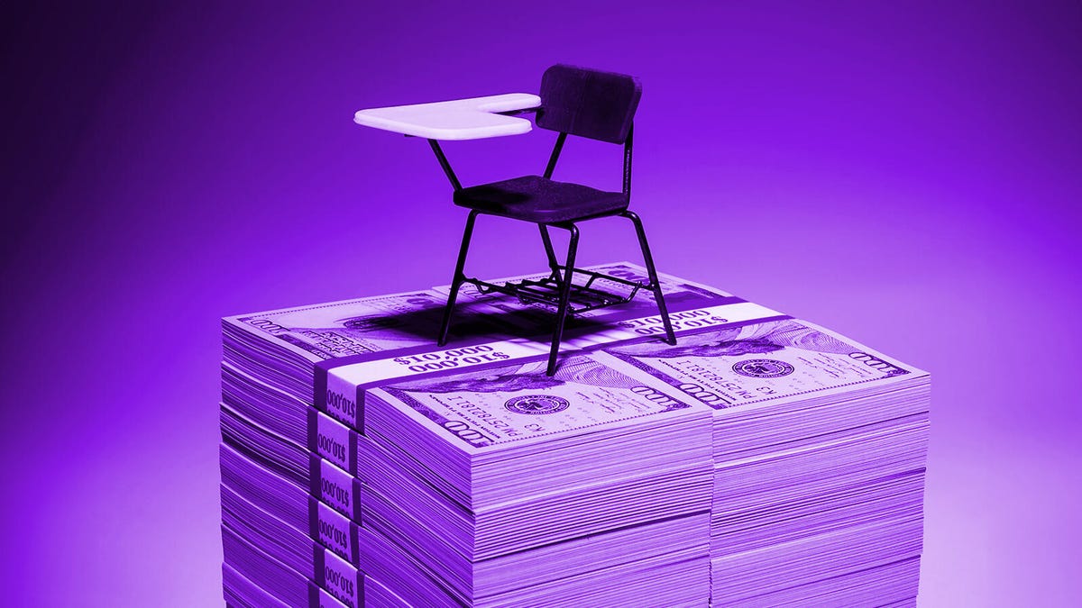 Student desk on top of a stack of $100 bills