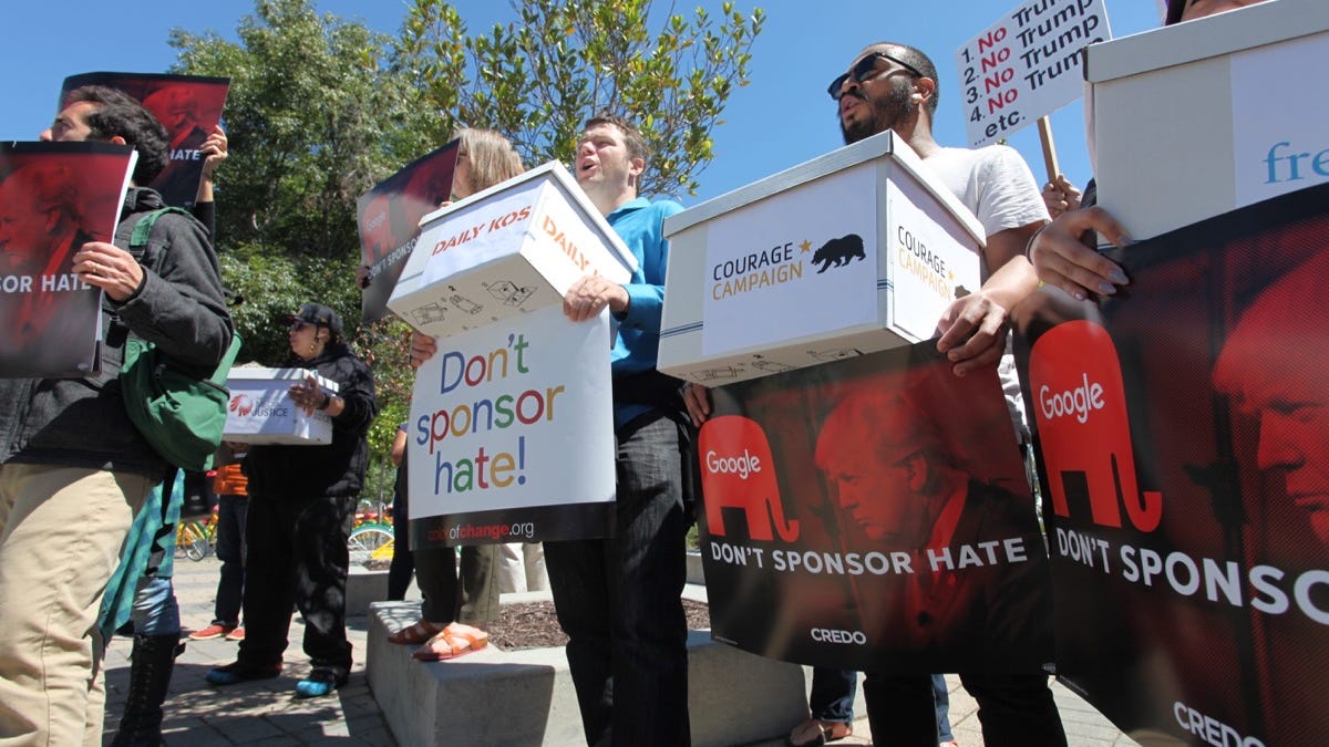 Protesters carrying Dump Trump signs