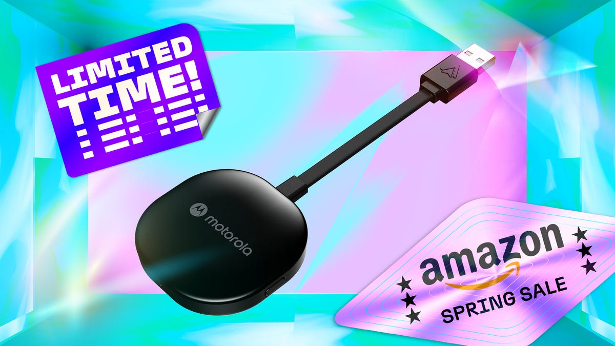 Motorola’s black wireless-to-USB Android Auto dongle floats over a colorful backdrop