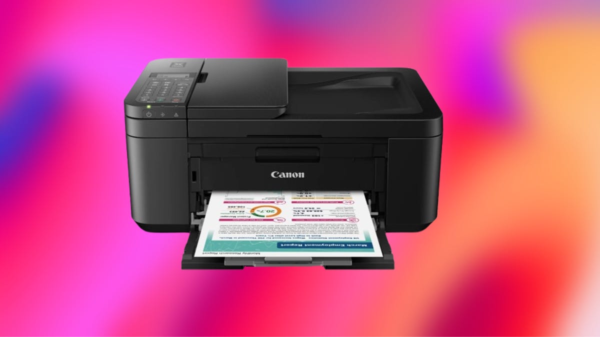 Black Canon printer with document printout on document feeder compartment. Background: purple, hot pink and orange gradient.