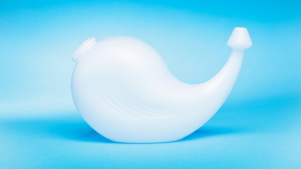A neti pot against light blue background