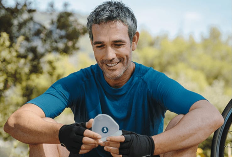 A man holding a case of Reveal aligners 