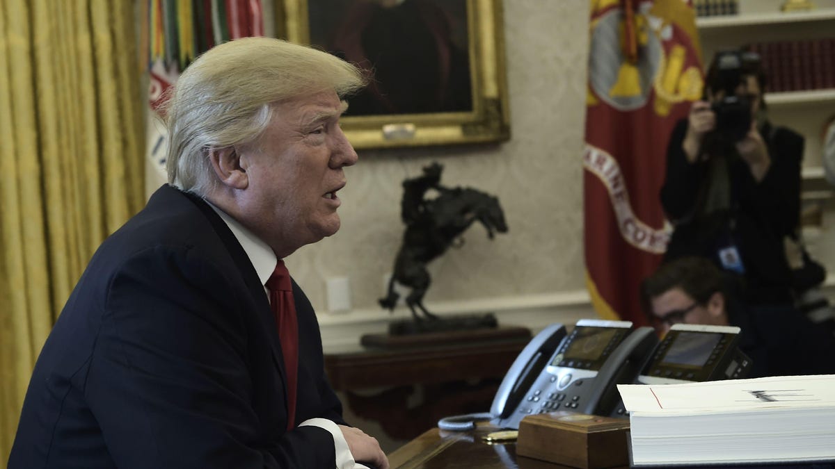 US President Donald Trump at his desk in the Oval Office.