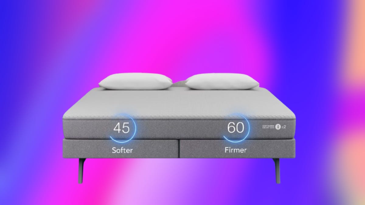 Grey c2 Sleep Number smart bed with headboard against purple and pink background.