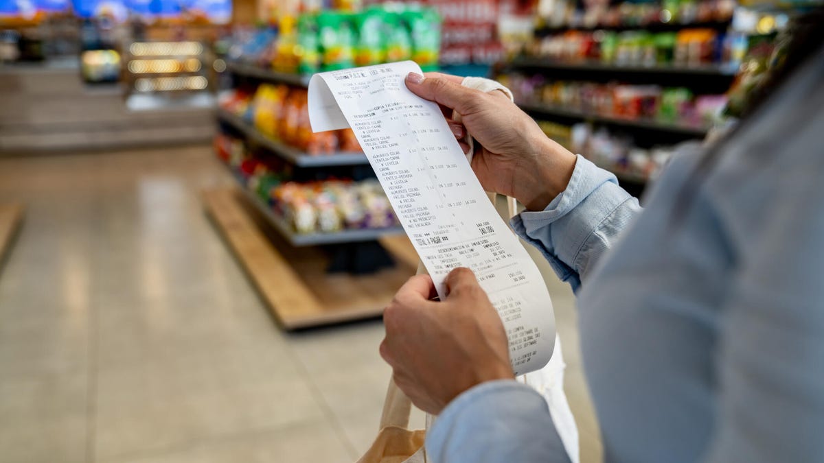 person holding grocery receipt