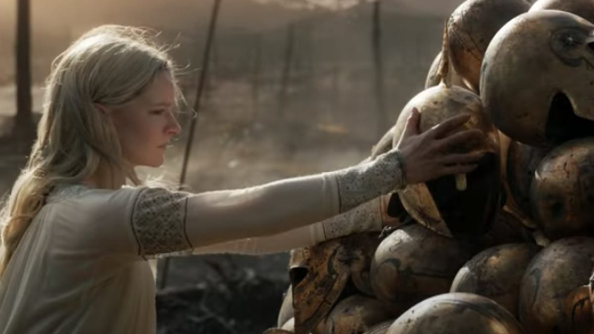 Galadriel reaching to a pile of Elven helmets after a battle