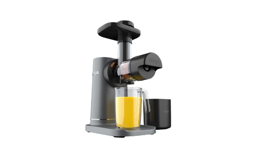 A juicer on a white background making orange juice