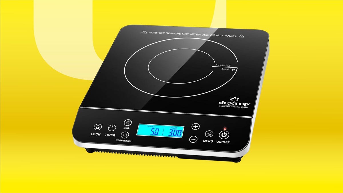 A square, black electronic cooktop, set against a bright yellow background.