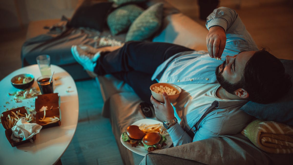 man eats fast foods on couch