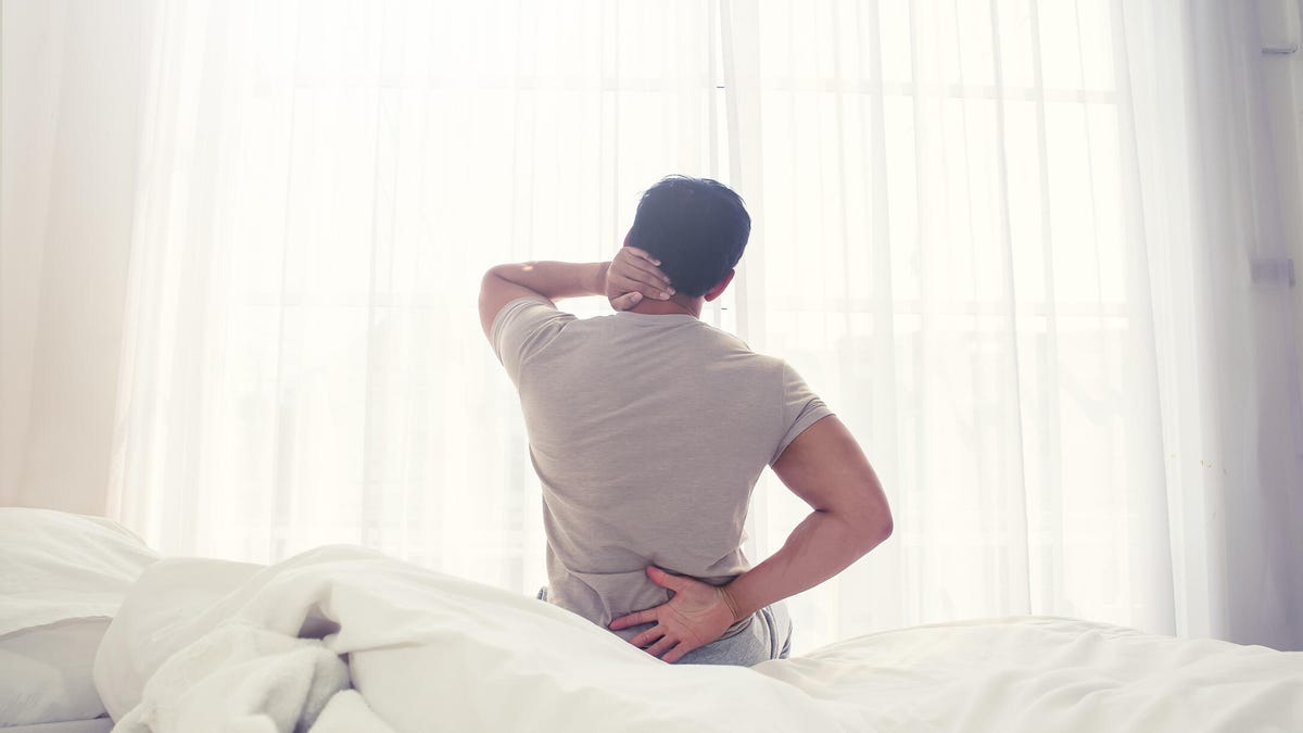 Man with severe pain on a white bed