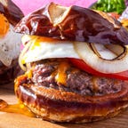 A juicy hamburger topped with egg and onion