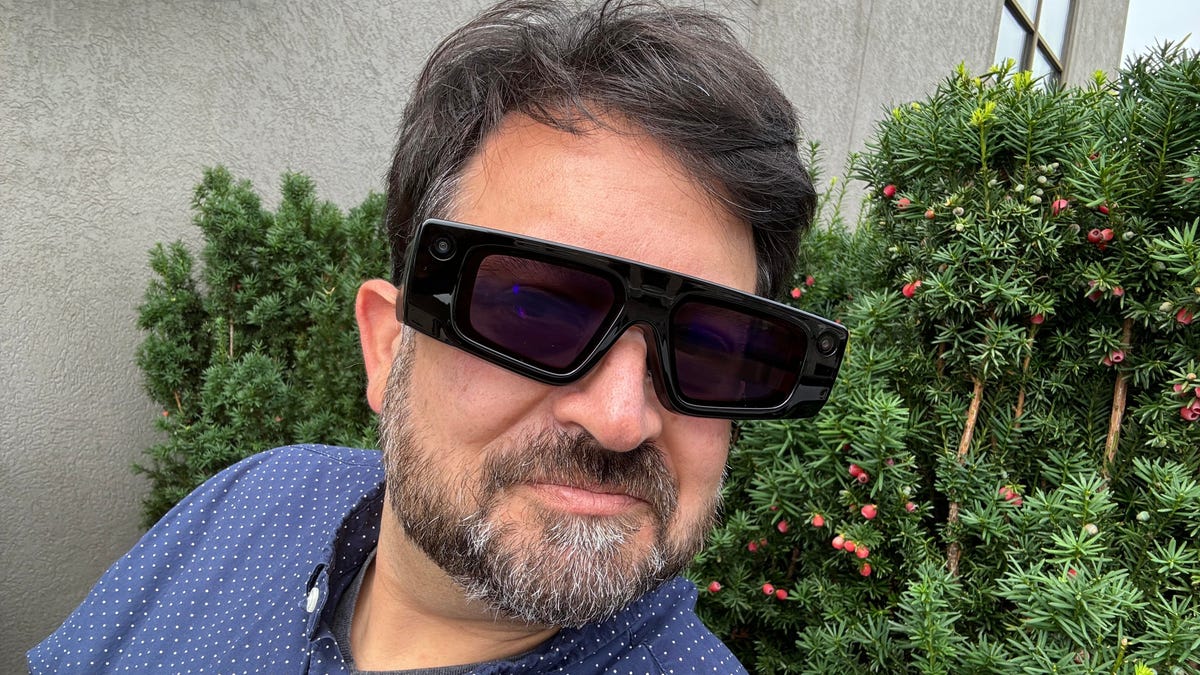 A man wearing big, dimming AR sunglasses