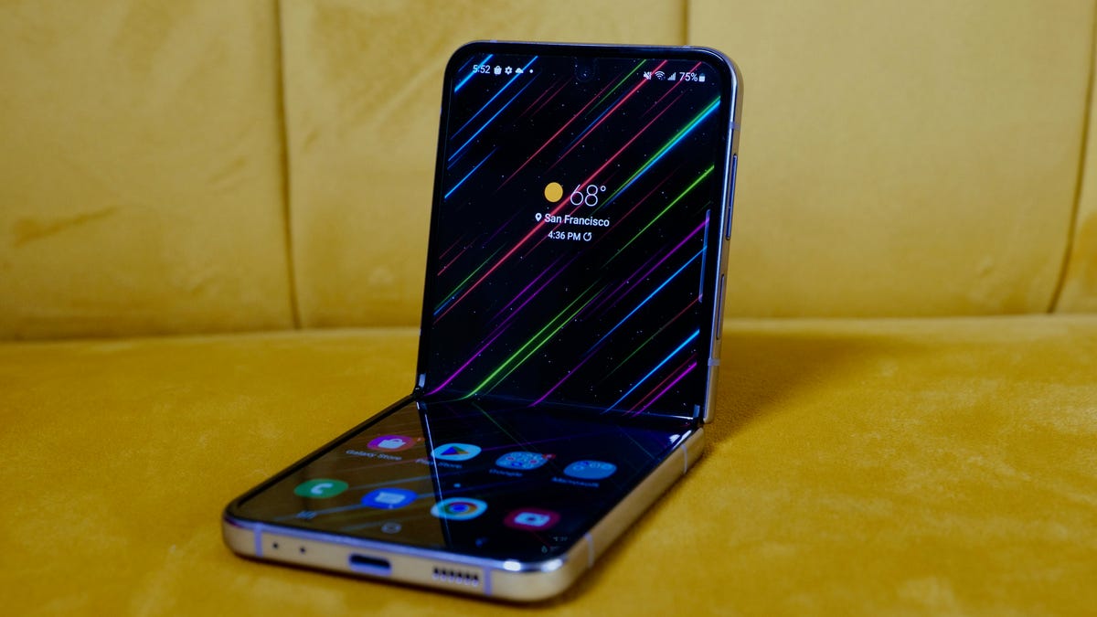 The Galaxy Z Flip 4 in Flex Mode on a yellow couch