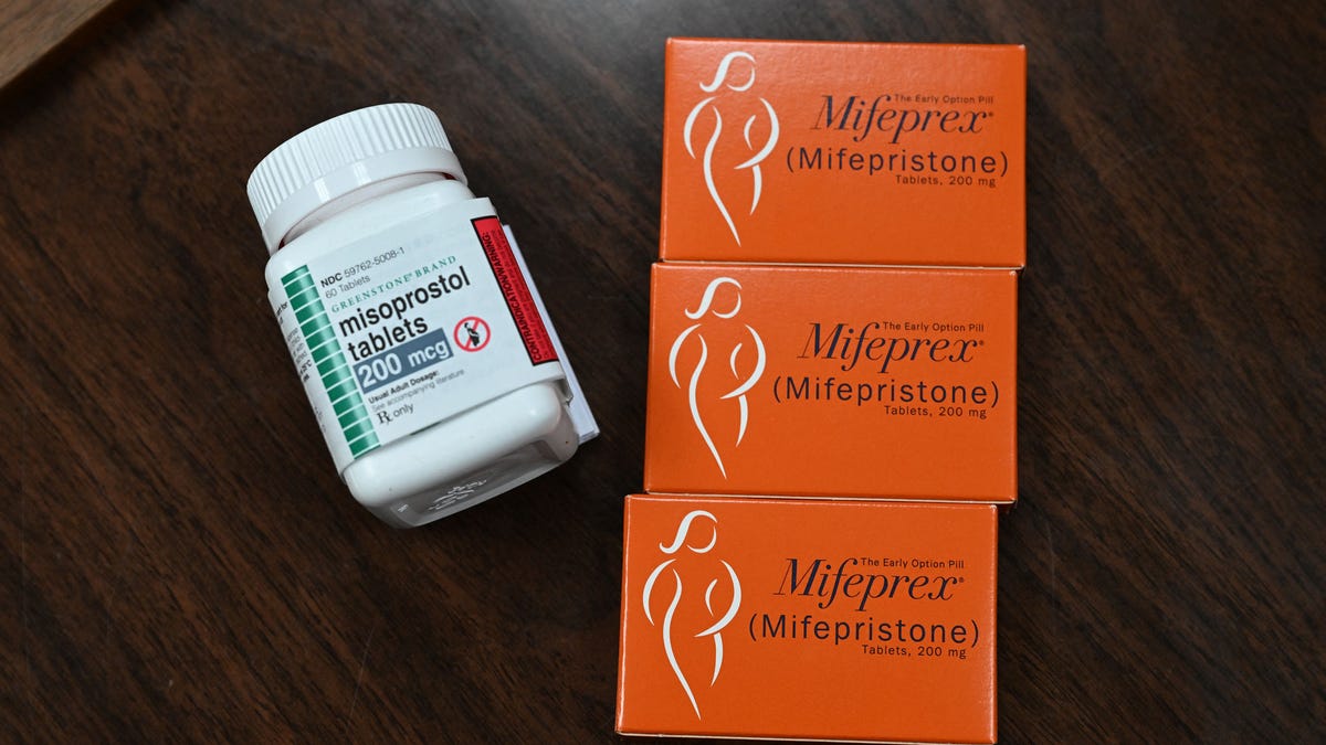 Three orange boxes of Mifeprex next to a bottle of misoprostol