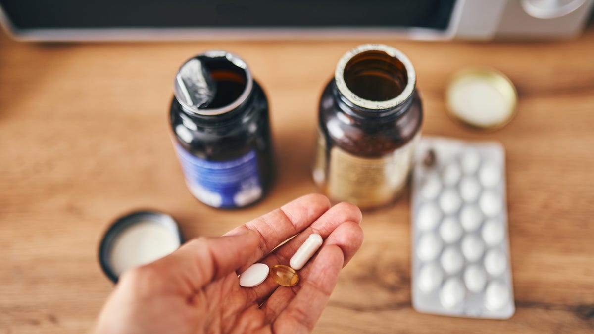 Person holding vitamins with bottles