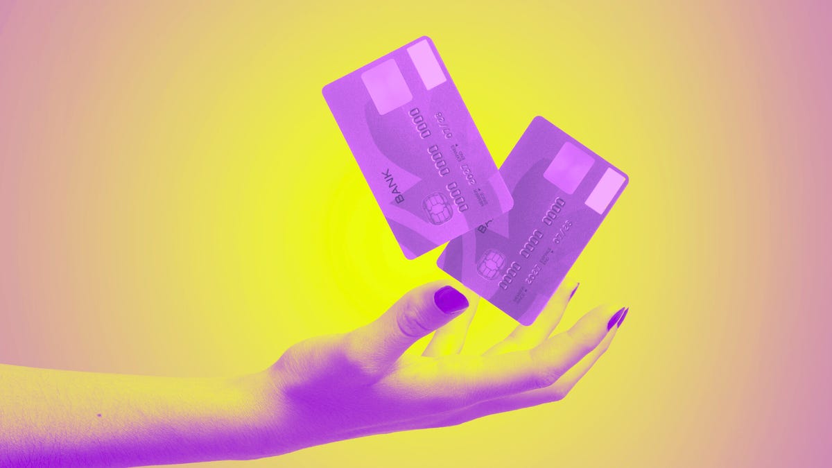 Two credit cards hovering in the palm of a hand.