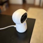 Aqara's G3 camera hub on a black desk.