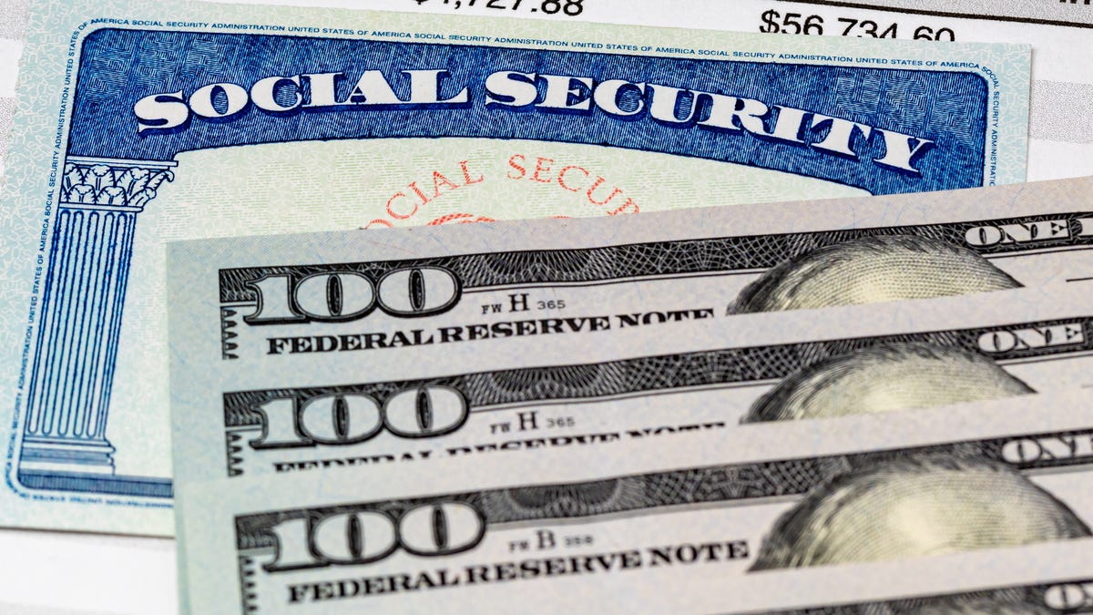 Three $100 bills on top of a Social Security card