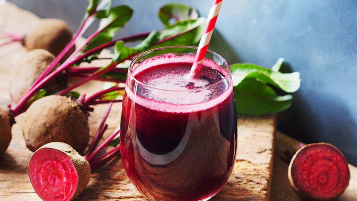 beet juice in glass surrounded by beets