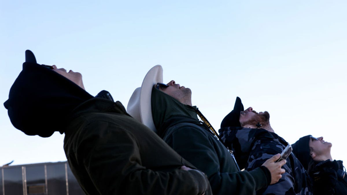 Onlookers watch as Blue Origin's New Shepard flies toward space carrying Good Morning America co-anchor Michael Strahan, Laura Shepard Churchley, daughter of astronaut Alan Shepard, and four other civilians on Dec.11, 2021.
