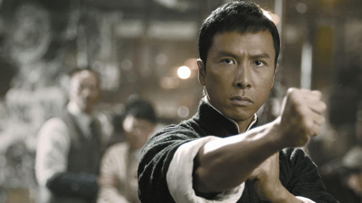 A man holds out his fist while practicing martial arts in Ip Man