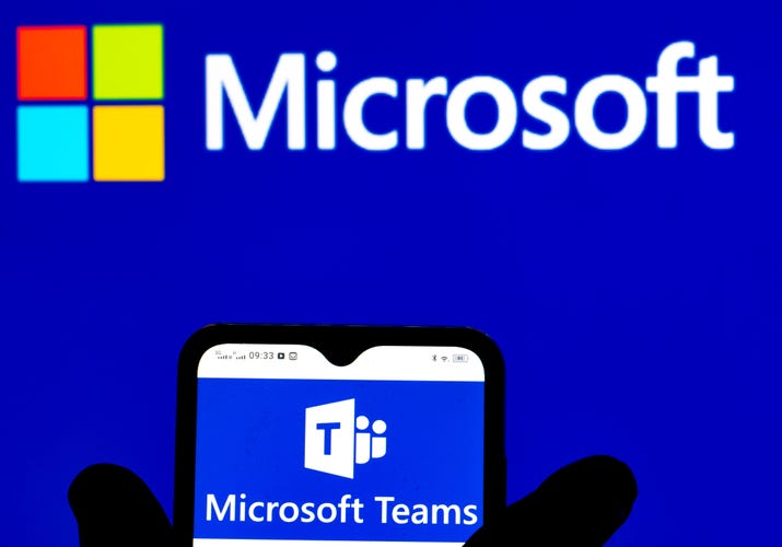 Microsoft Teams logo displayed on phone and Microsoft logo in the background