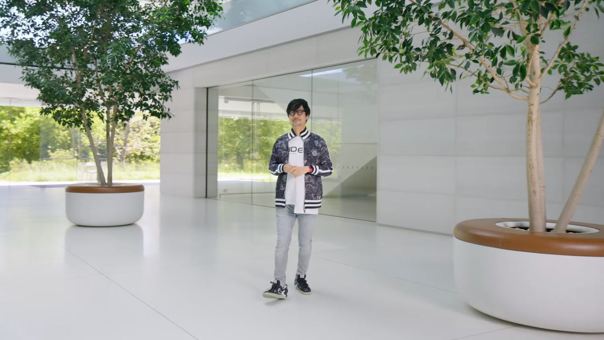 hideo kojima standing between two potted plants in apple's campus