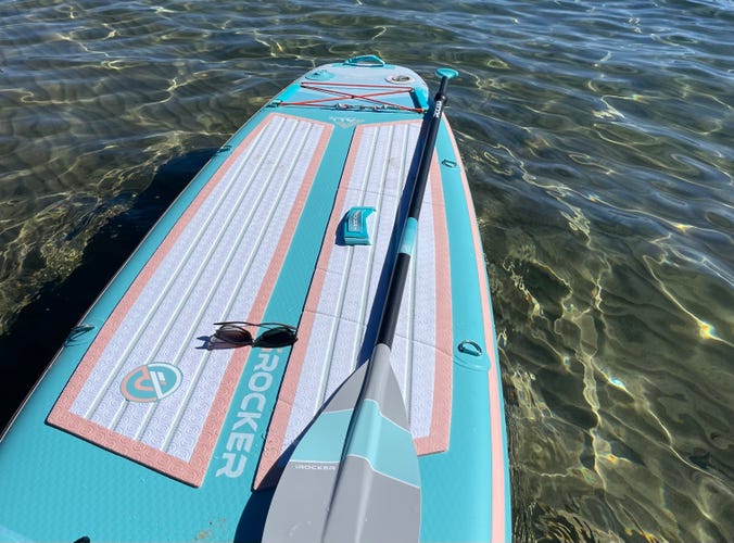 IRocker Paddle Board with its paddle floating in Lake Tahoe