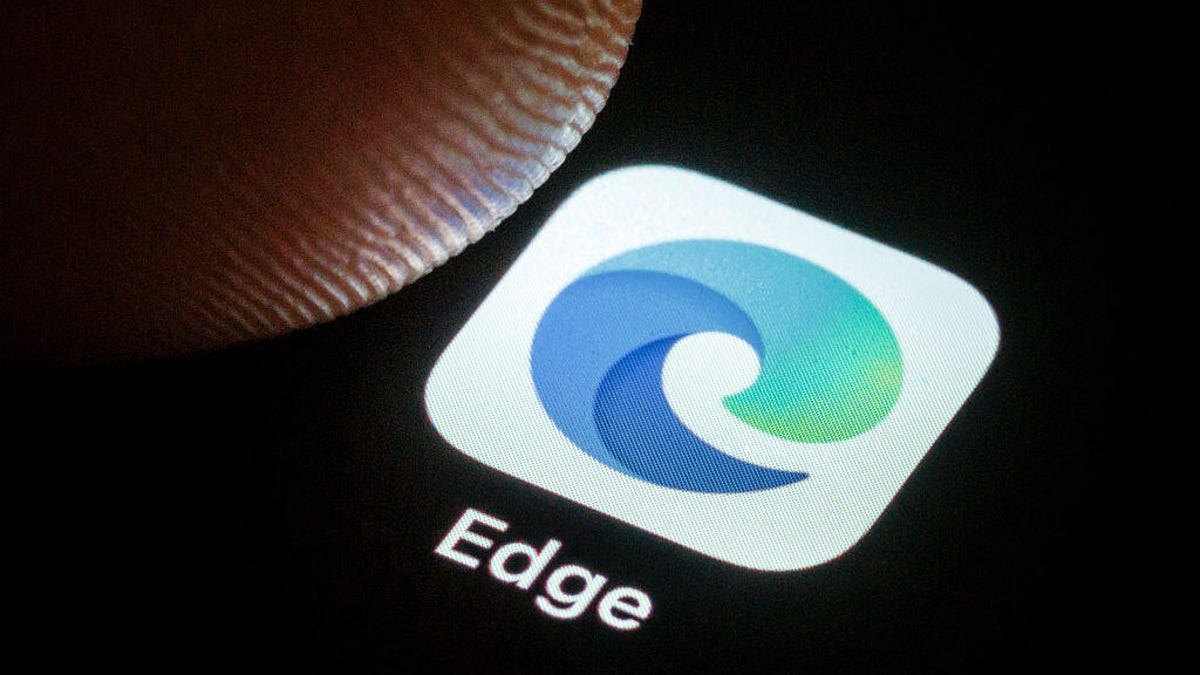 A person's thumb hovers over the Microsoft Edge phone icon.