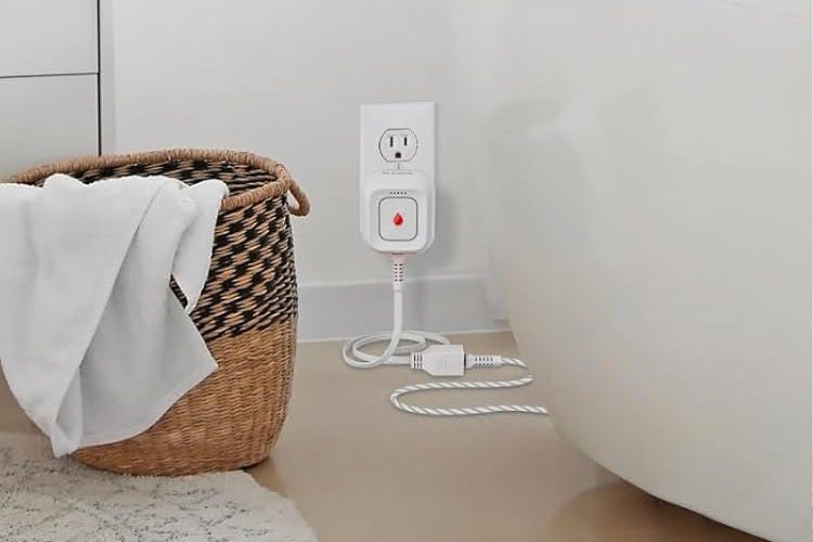 A plug-in D-Link water detector next to a tub and laundry basket.