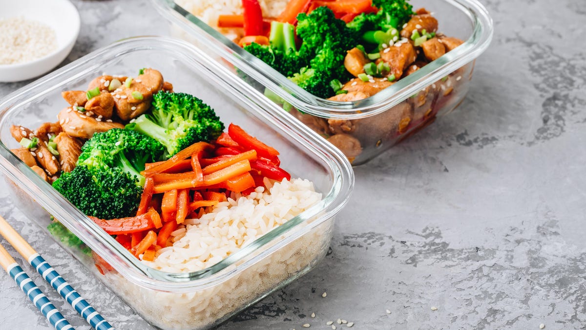 two meal prep containers filled with rice, meat and veggies