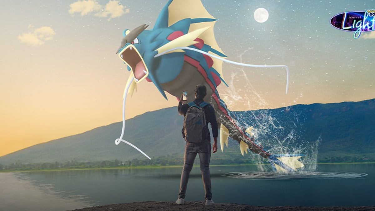 A trainer watching Mega Gyarados leap out of a lake