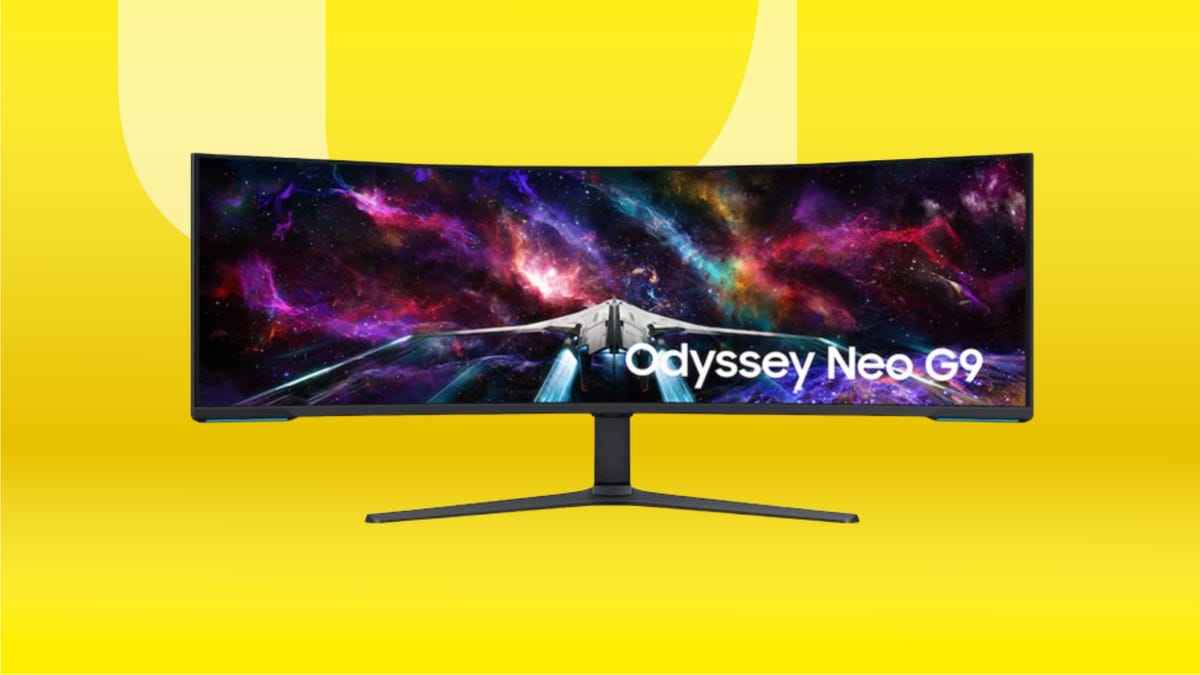 Black curved Samsung monitor on black stand against yellow gradient background.