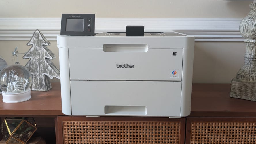 A white laser printer on a wooden counter