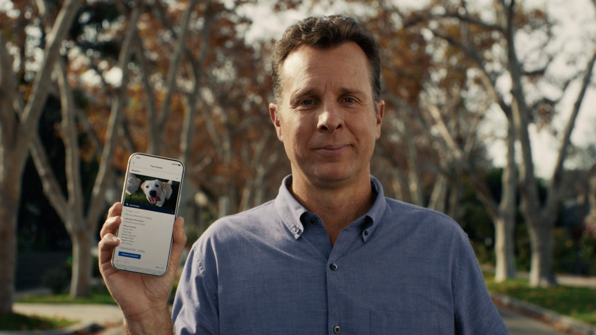 A man holds a phone with Ring's Search Party function showing a dog.