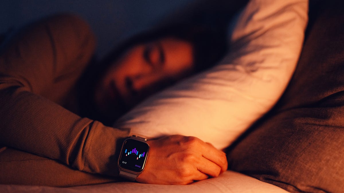 Person sleeping with a wearable sleep tracker in bed