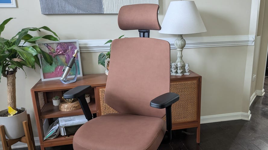 A brown leather chair in front of a entertainment center