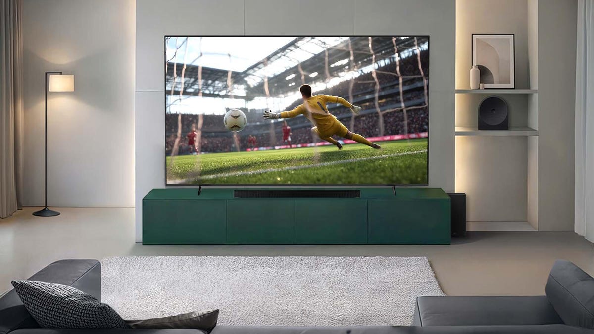 Wall mounted Samsung TV with a soccer player kicking a ball