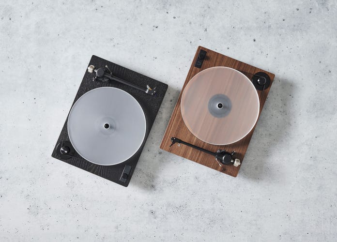 Two U-Turn Orbit Theory turn tables in walnut or ebonized wood on a grey marble background. 