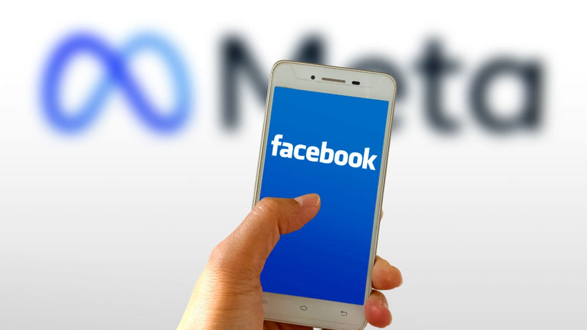 Facebook logo on a phone screen, with the Meta logo in the background