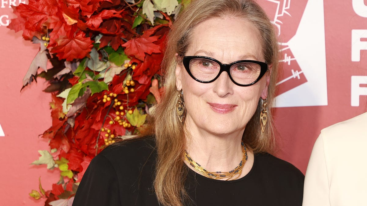 Meryl Streep wearing glasses with flowers in background