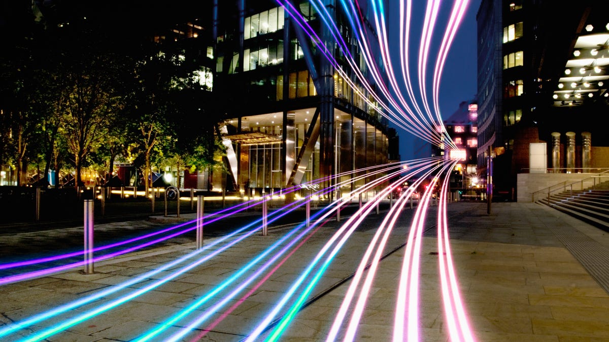 Wavy lines of light swoop across a city plaza