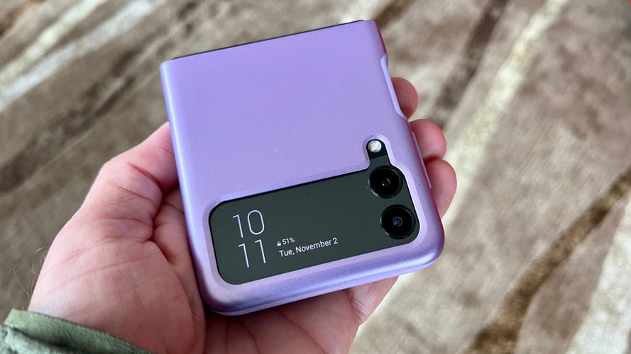 A hand holds a phone in a purple Spigen Thin Fit Galaxy Z Flip 3 case.